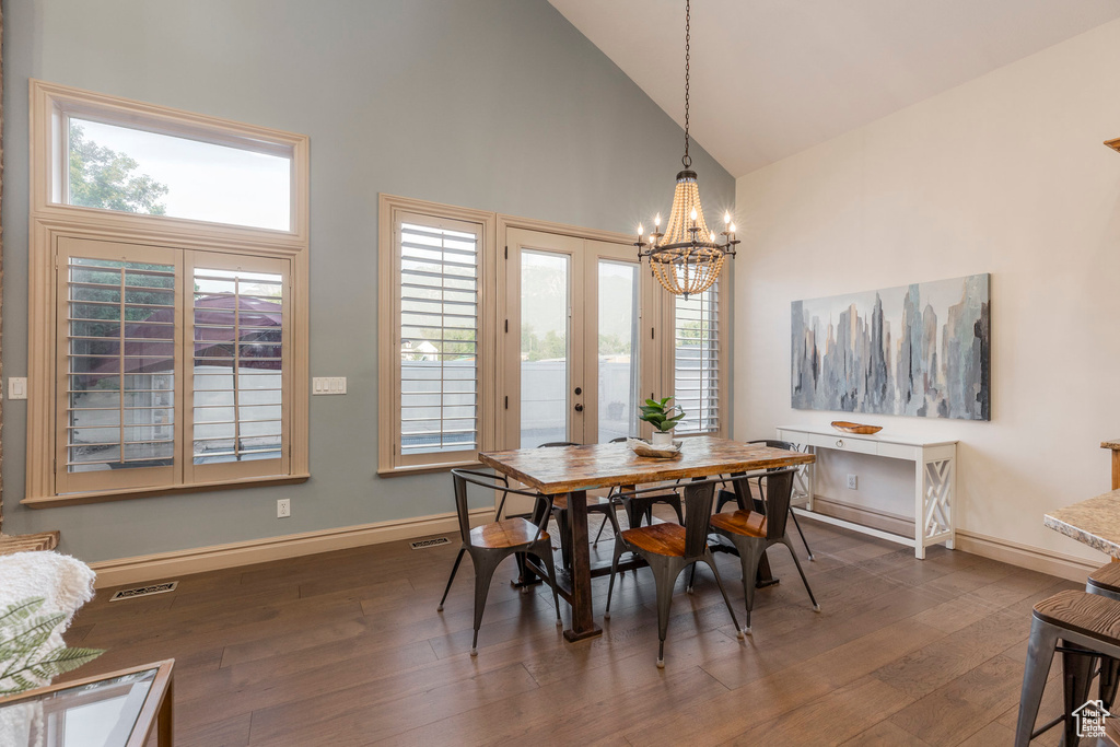 Dining area featuring high vaulted ceiling, a chandelier, dark wood finished floors, healthy amount of natural light, and french doors