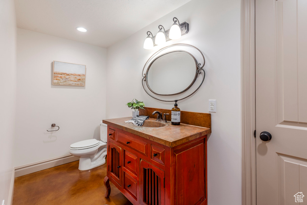 Bathroom with vanity, concrete flooring, and recessed lighting