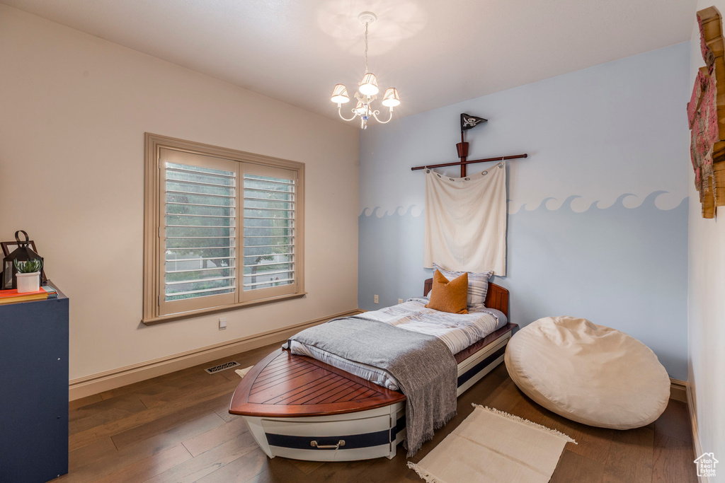 Bedroom featuring a chandelier and wood finished floors