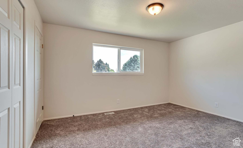 Unfurnished bedroom with carpet flooring and baseboards
