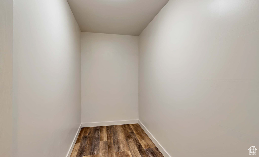Empty room featuring dark wood-type flooring and baseboards