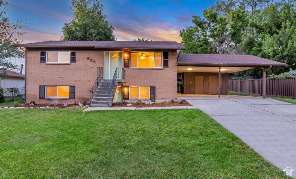 View of front of house featuring brick siding, concrete driveway, and an attached carport
