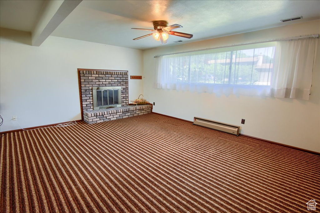 Unfurnished living room featuring a baseboard radiator, carpet flooring, ceiling fan, and a fireplace