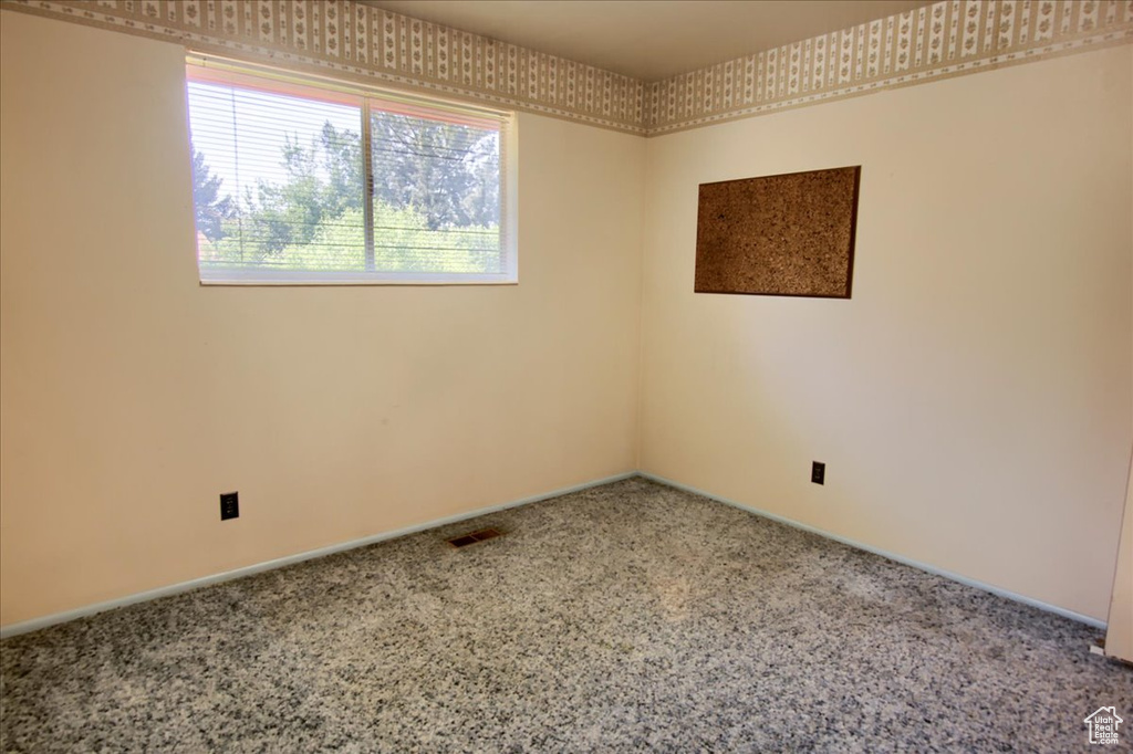 Carpeted spare room with baseboards