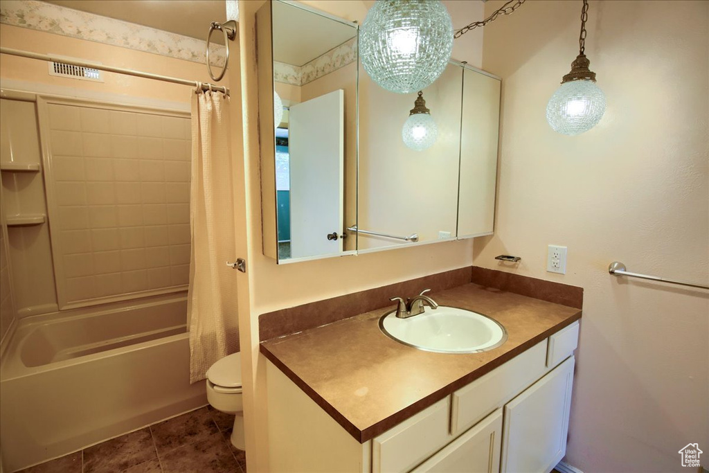 Full bath with vanity, shower / bath combo with shower curtain, and tile patterned flooring