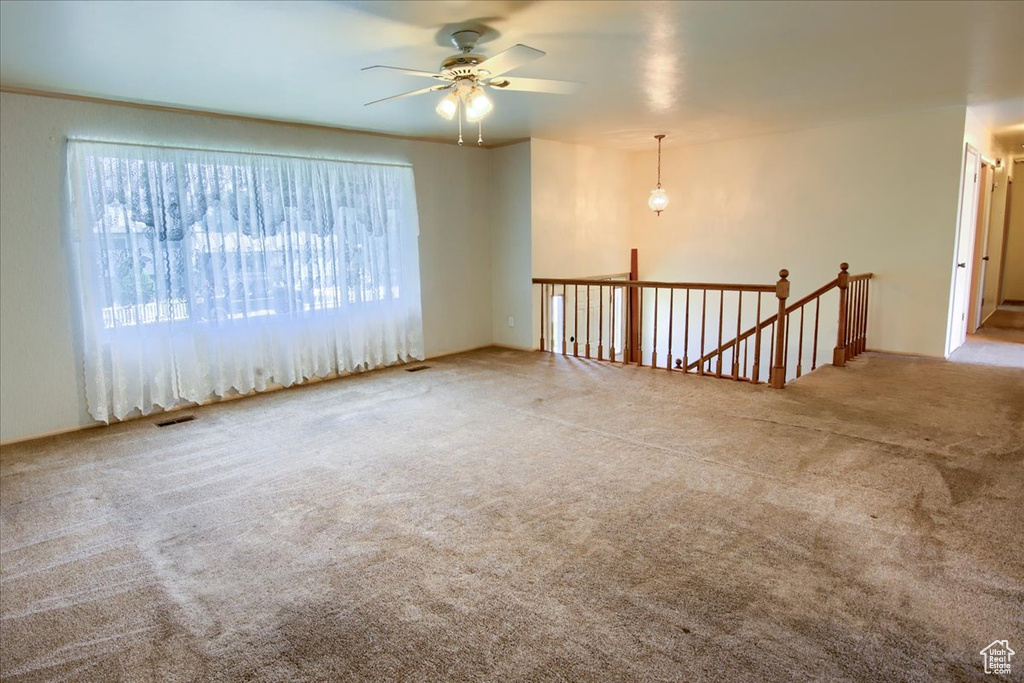 Carpeted empty room with a ceiling fan