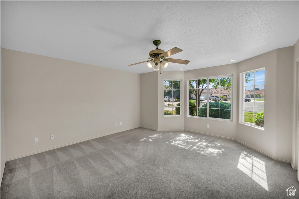 Unfurnished room with healthy amount of natural light, carpet, ceiling fan, a textured ceiling, and recessed lighting