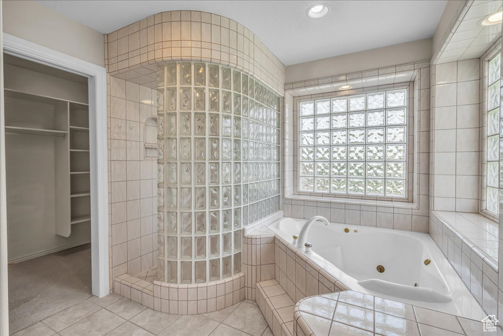 Bathroom featuring a whirlpool tub, walk in shower, tile patterned flooring, plenty of natural light, and recessed lighting