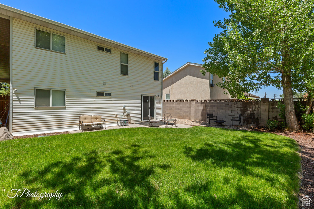 Back of house with a fenced backyard and a patio