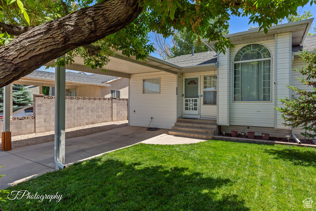 Ranch-style house featuring entry steps, roof with shingles, and a patio area