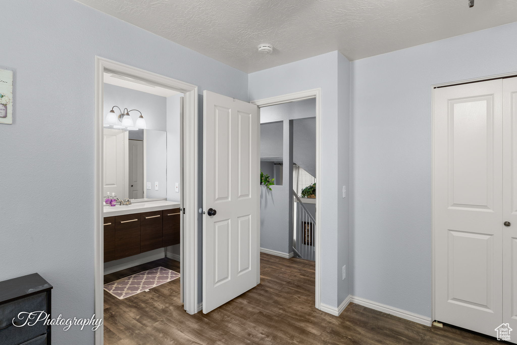 Bedroom featuring dark wood-style floors, a closet, and ensuite bathroom