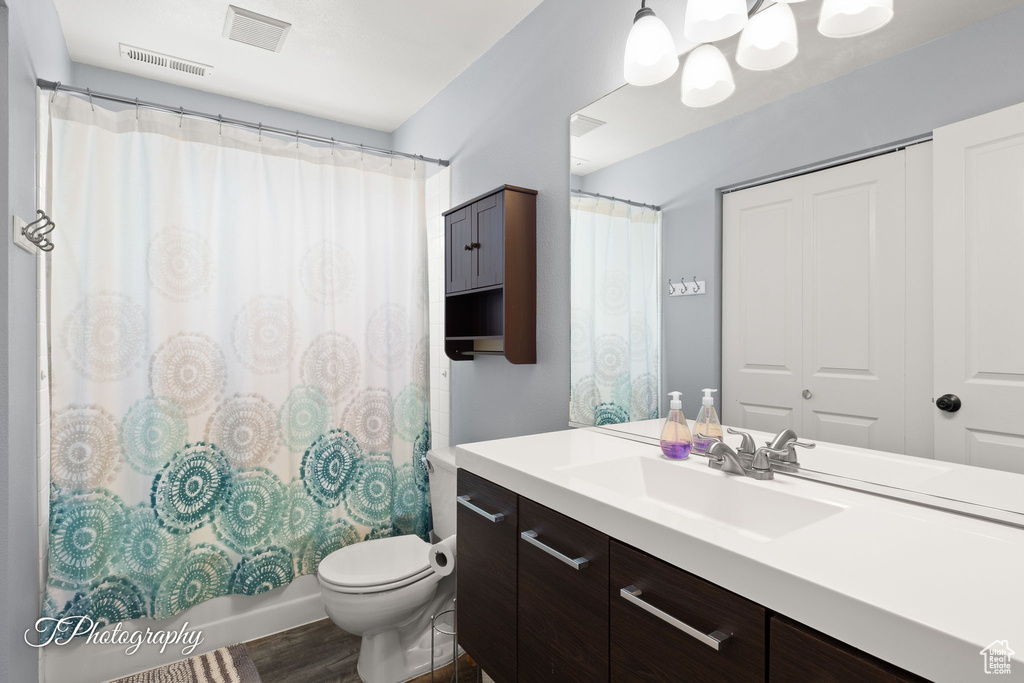 Bathroom featuring vanity, wood finished floors, and shower / tub combo with curtain