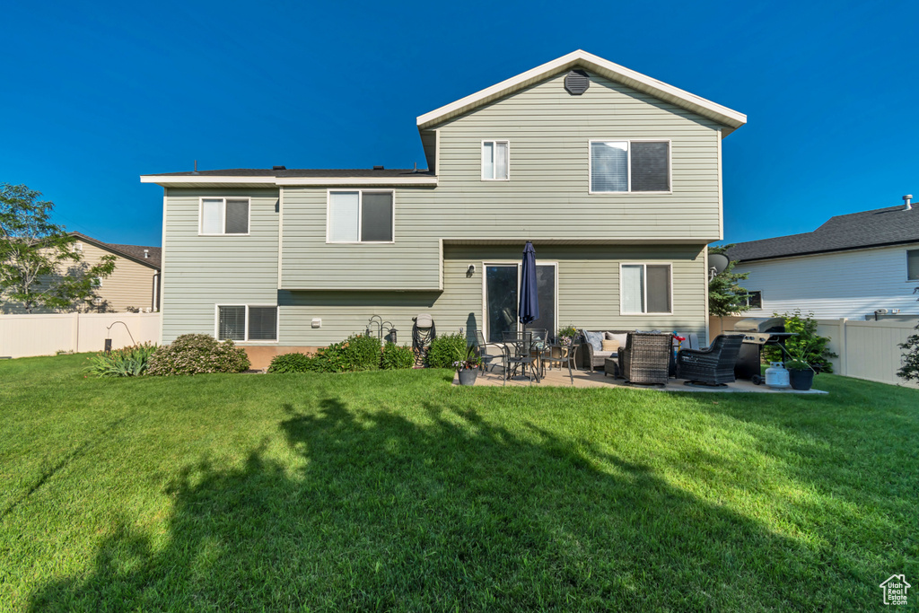 Rear view of property with a fenced backyard, a patio area, and an outdoor living space