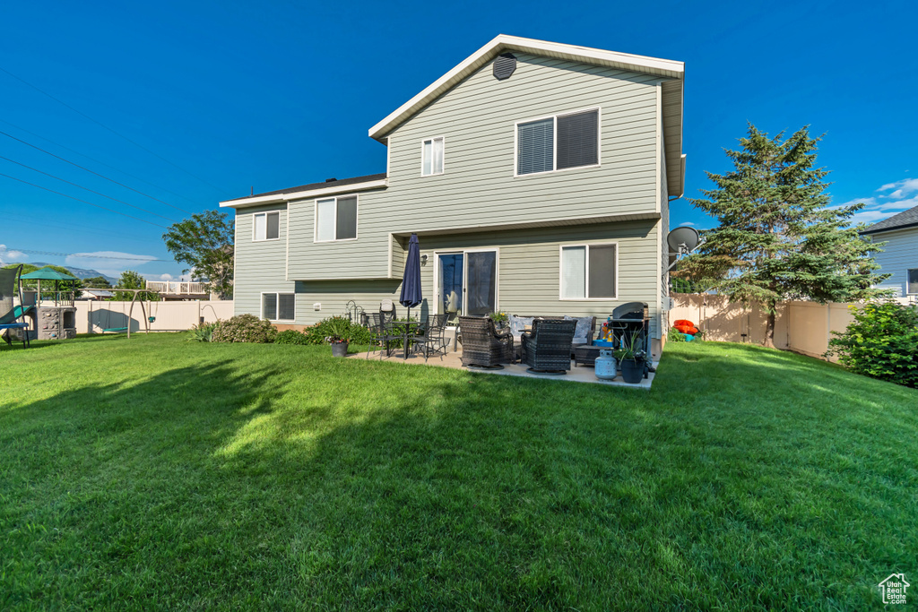 Rear view of house with a fenced backyard, a patio, and an outdoor living space