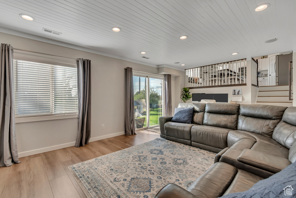 Living area featuring recessed lighting, light wood-style flooring, wood ceiling, and stairs