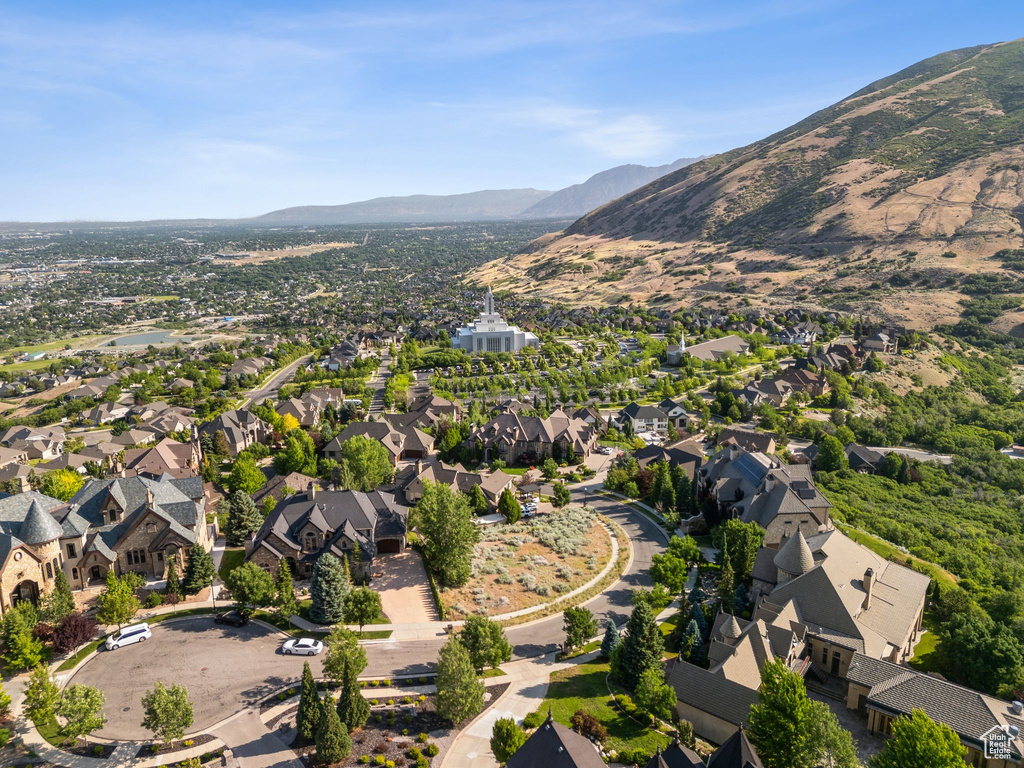 Aerial view of property and surrounding area with a mountain backdrop and nearby suburban area