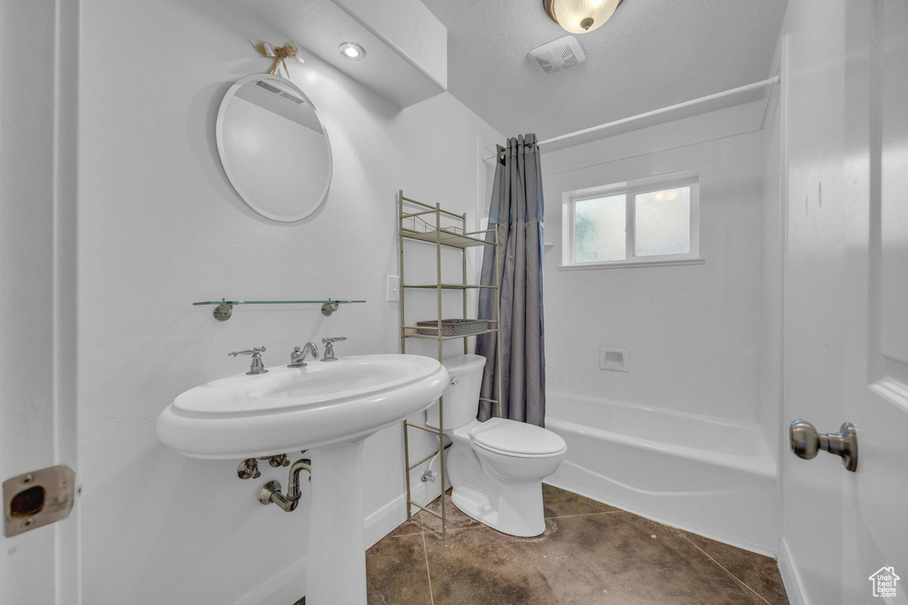 Bathroom with shower / bath combination with curtain and toilet