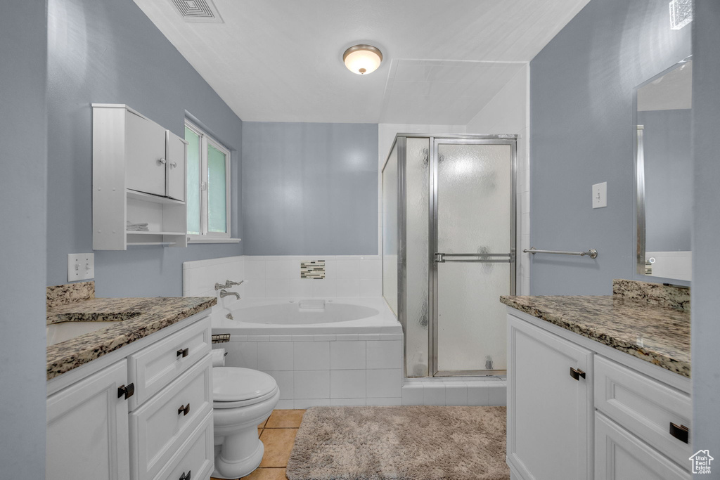 Bathroom featuring vanity, a stall shower, a garden tub, and tile patterned floors