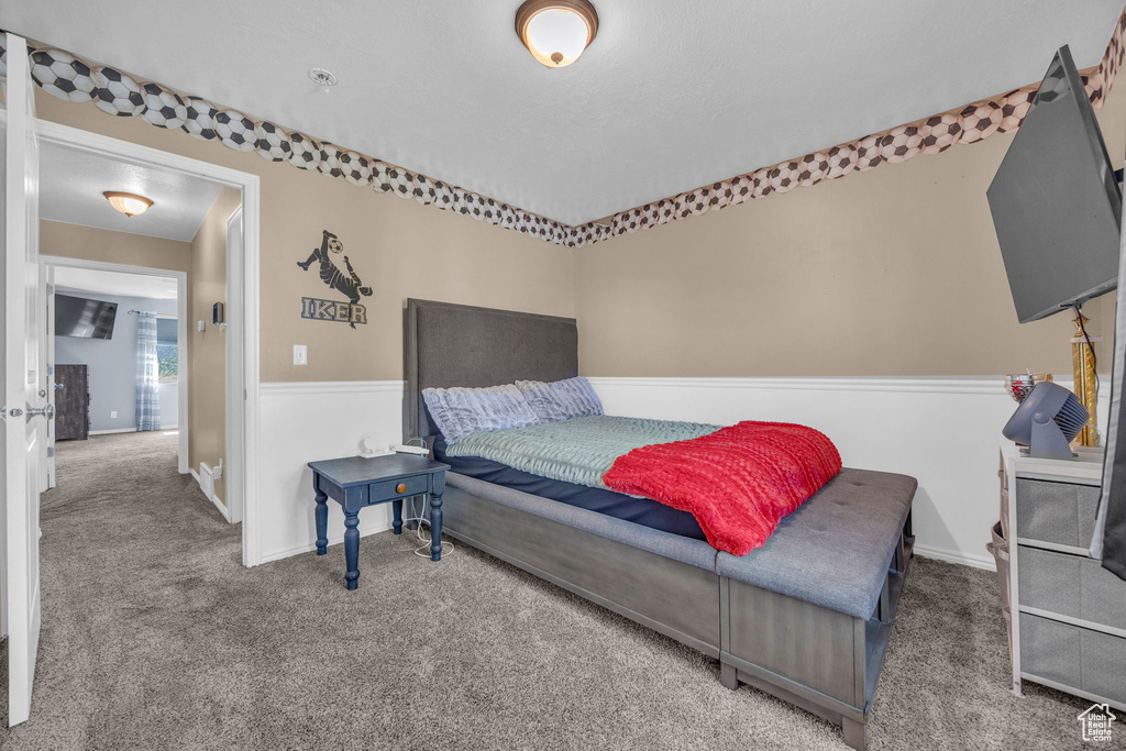 Bedroom featuring carpet and baseboards