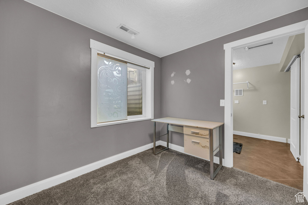 Office space with baseboards and a textured ceiling