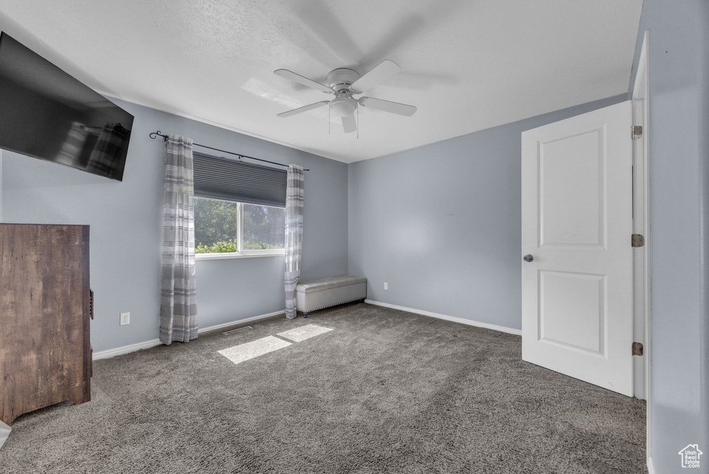 Unfurnished bedroom featuring carpet floors and ceiling fan