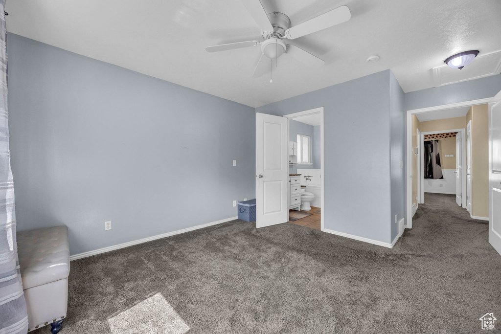 Unfurnished bedroom featuring carpet floors, connected bathroom, and a ceiling fan