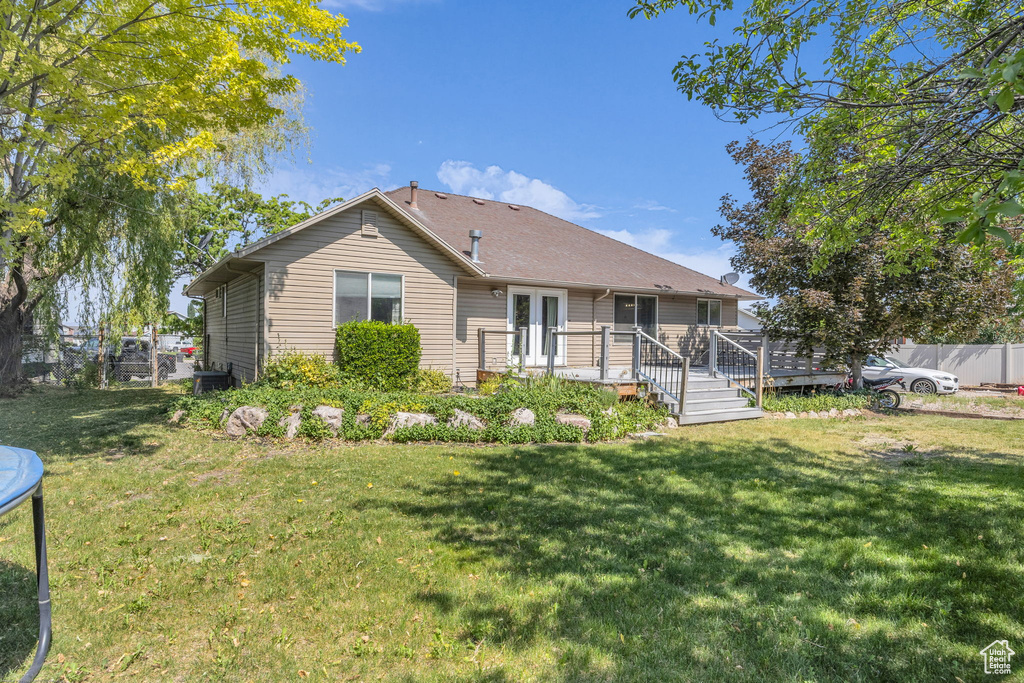 Rear view of property featuring a deck and a trampoline
