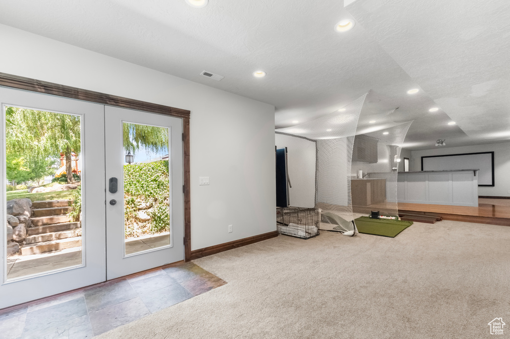 Unfurnished living room with carpet, recessed lighting, and french doors
