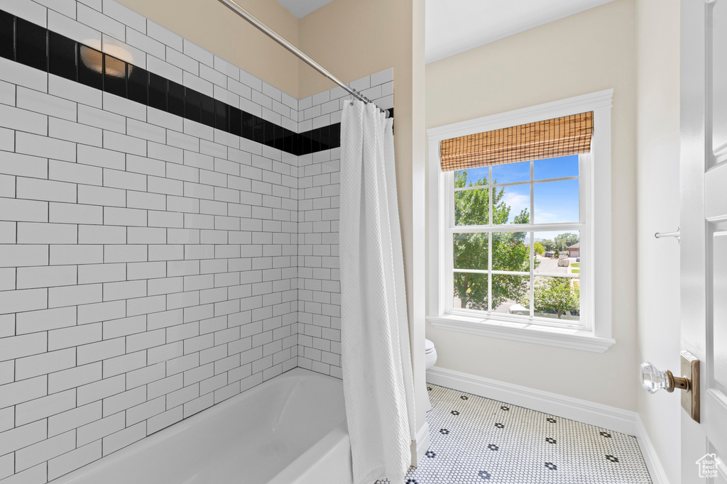 Bathroom with shower / bath combination with curtain and tile patterned flooring
