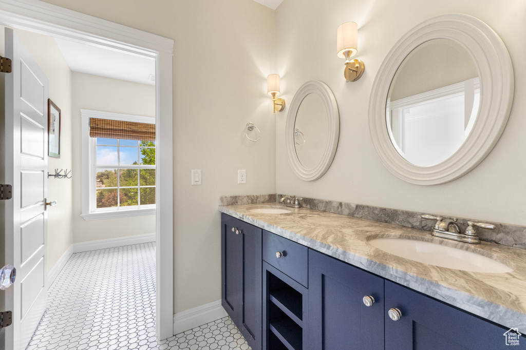 Full bathroom featuring double vanity and baseboards