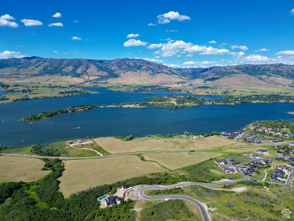 Aerial view of property and surrounding area with a water and mountain view