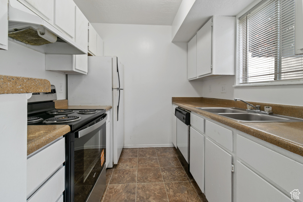 Kitchen featuring range with electric stovetop, white cabinetry, dishwasher, under cabinet range hood, and dark stone finish floors