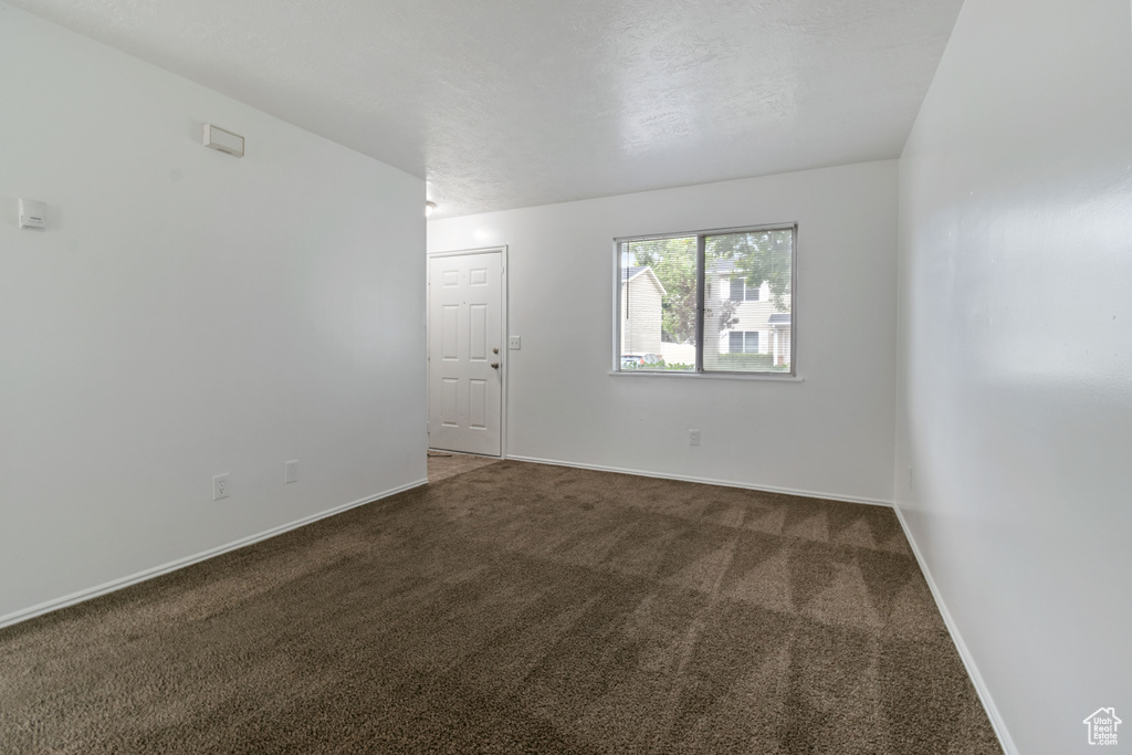 Spare room featuring carpet floors and baseboards
