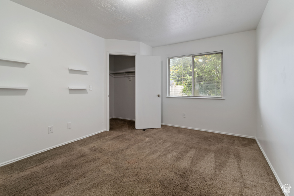 Unfurnished bedroom with carpet and a closet