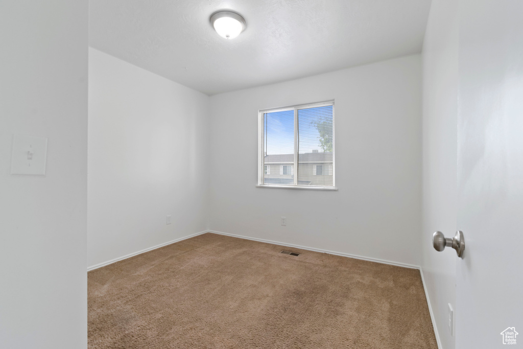 Spare room featuring carpet floors and baseboards