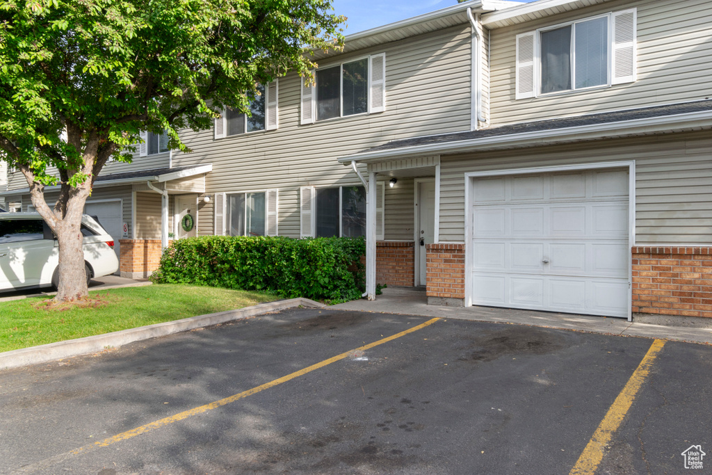 Multi unit property featuring brick siding and uncovered parking