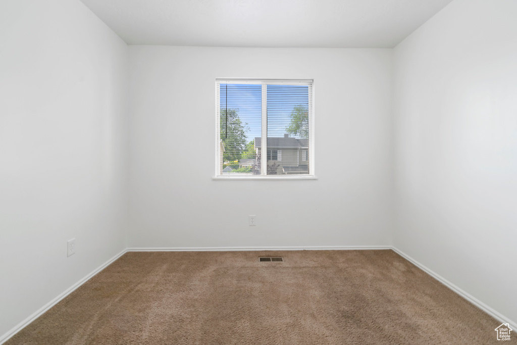 Carpeted empty room with baseboards