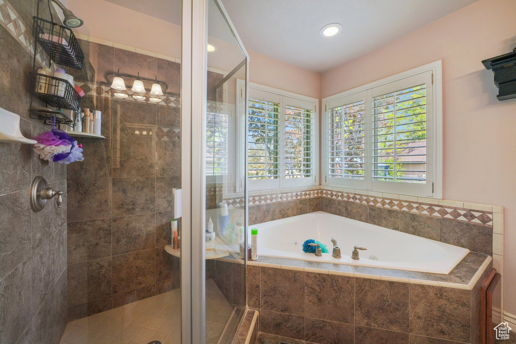 Bathroom with a stall shower, a bath, and recessed lighting