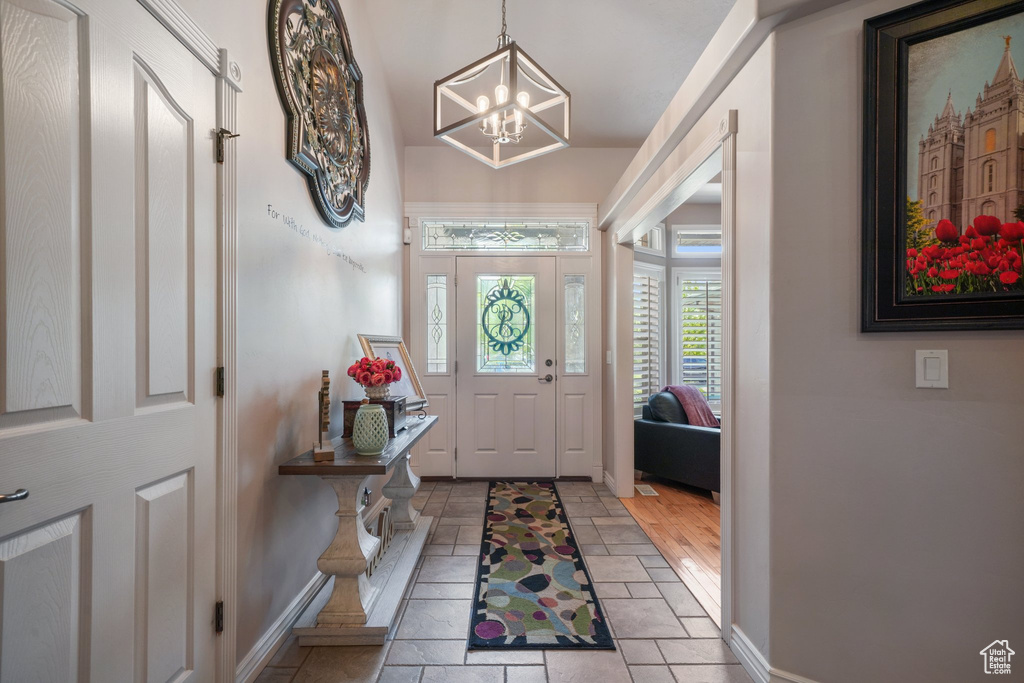 Entrance foyer featuring a chandelier and baseboards