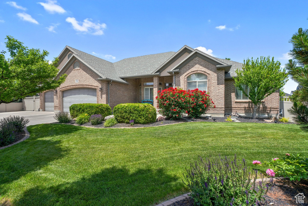 View of front of home with brick siding, a garage, driveway, and roof with shingles