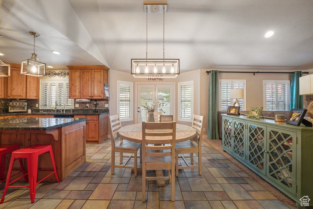 Dining area with healthy amount of natural light, light stone finish flooring, and recessed lighting
