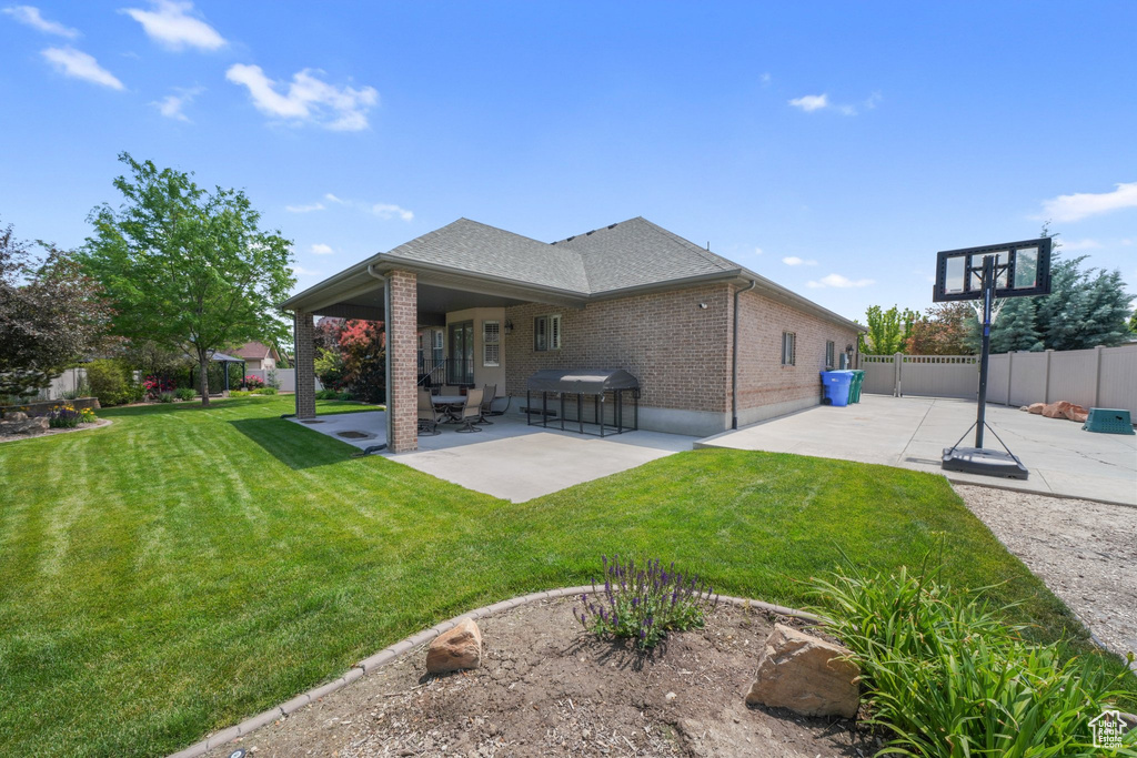 Rear view of house with a patio area, brick siding, and a shingled roof