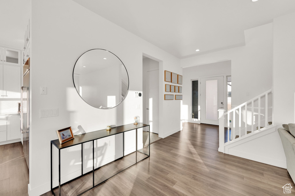 Foyer featuring stairs, wood finished floors, and recessed lighting