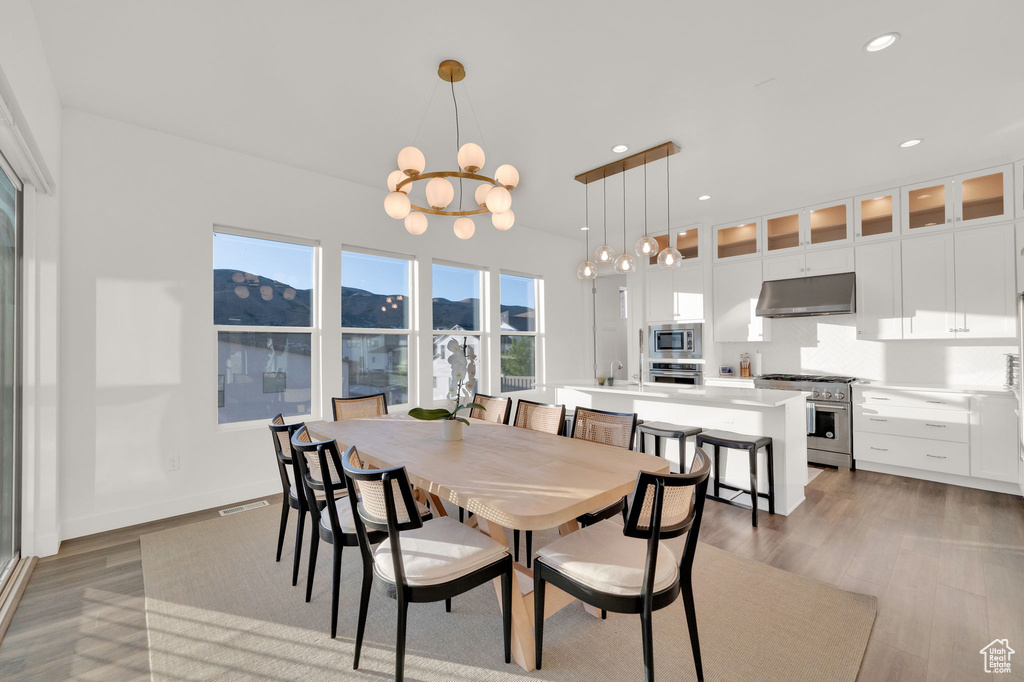 Dining space with a chandelier, wood finished floors, recessed lighting, and a mountain view