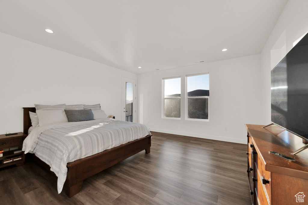 Bedroom with dark wood finished floors and recessed lighting