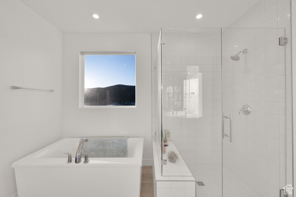 Full bathroom with a soaking tub, a shower stall, and recessed lighting