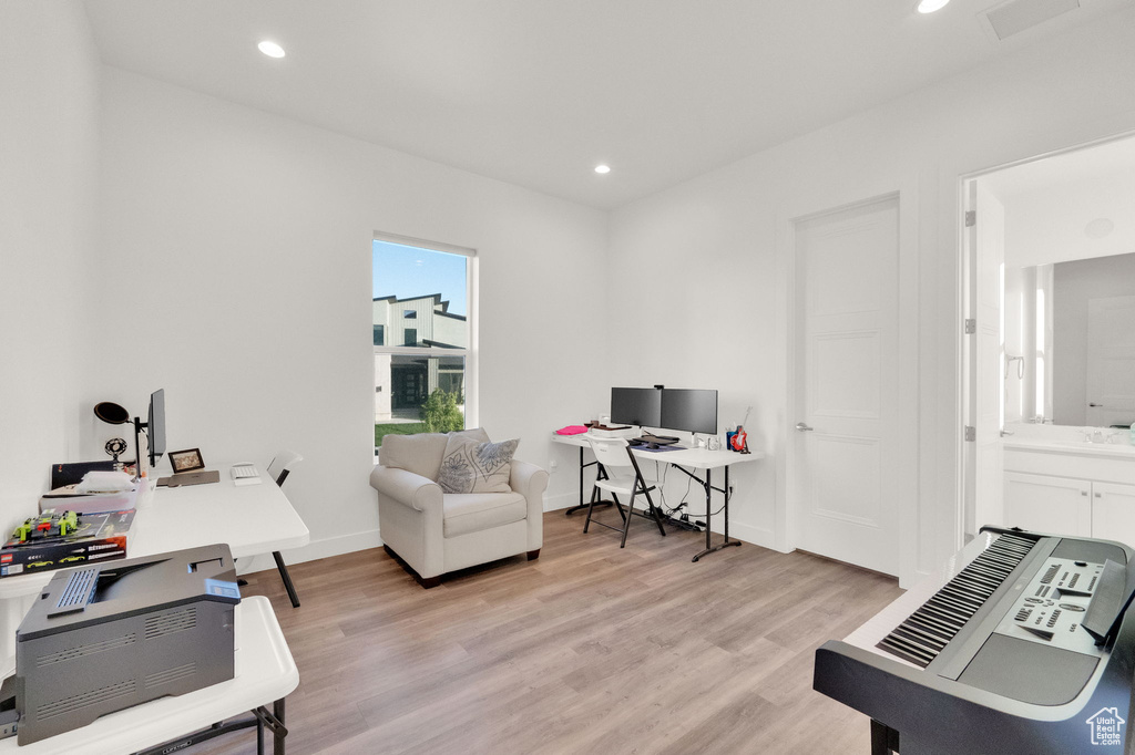 Office space with light wood-type flooring and recessed lighting