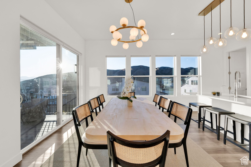 Dining room with a chandelier, light wood finished floors, a mountain view, and recessed lighting