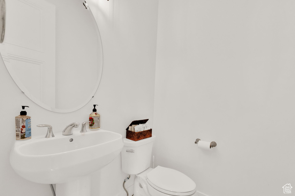 Half bathroom with baseboards and a sink