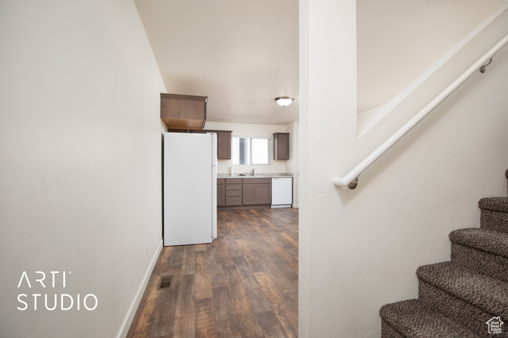 Staircase with wood finished floors and baseboards
